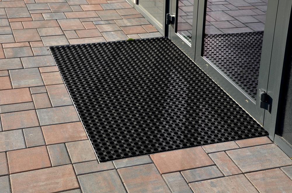 A rubber floor mat on a tile floor.