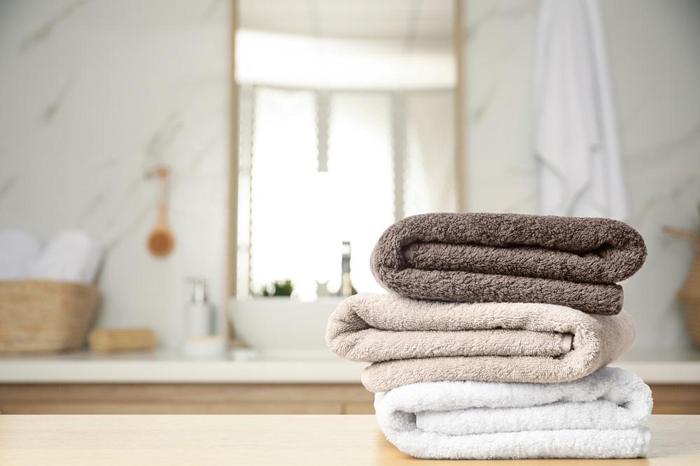 A stack of towels in front of a blurred background of a bathroom.