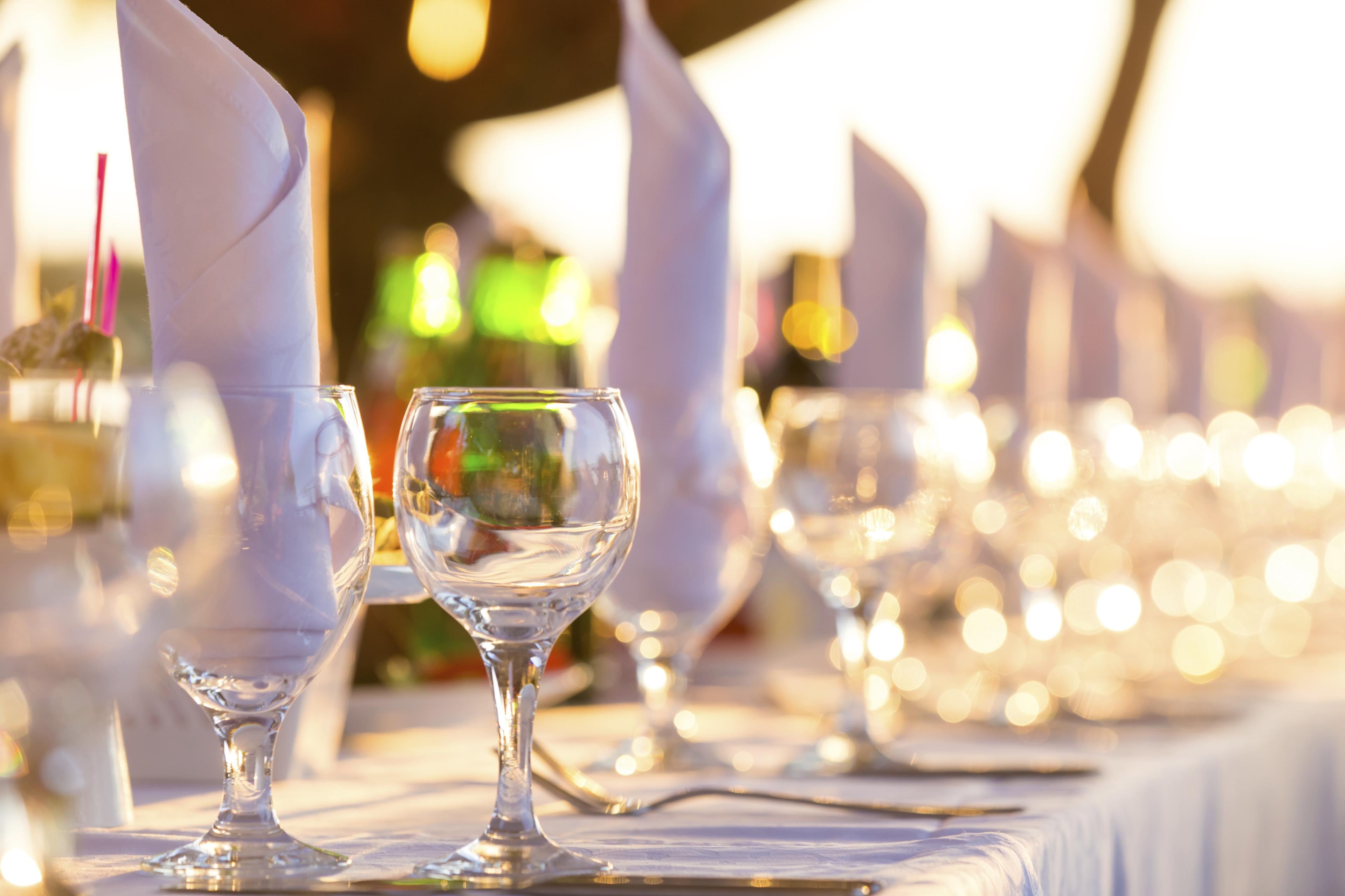 A row of clean wine glasses and linens on a table