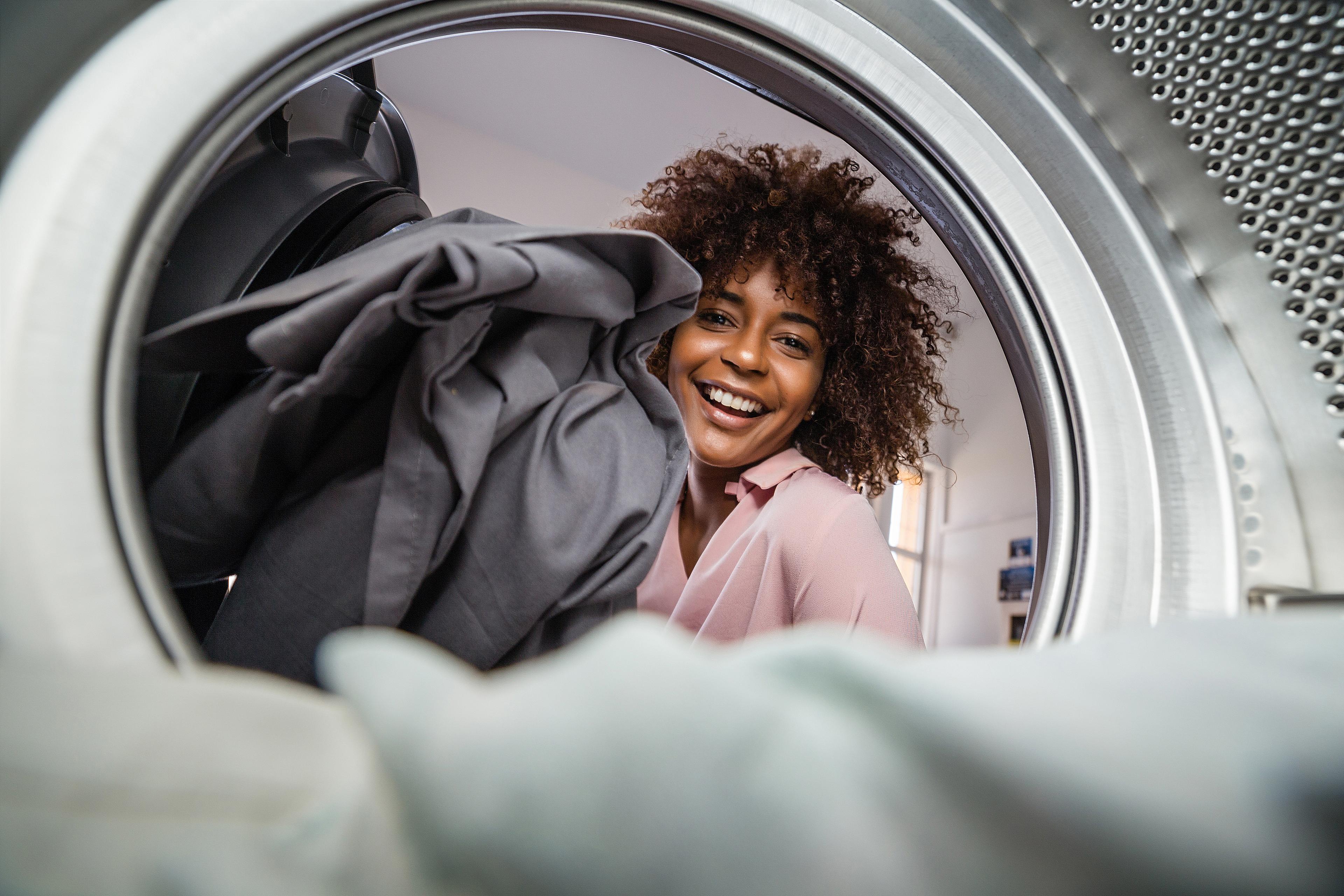 Women putting linens into a washing machine